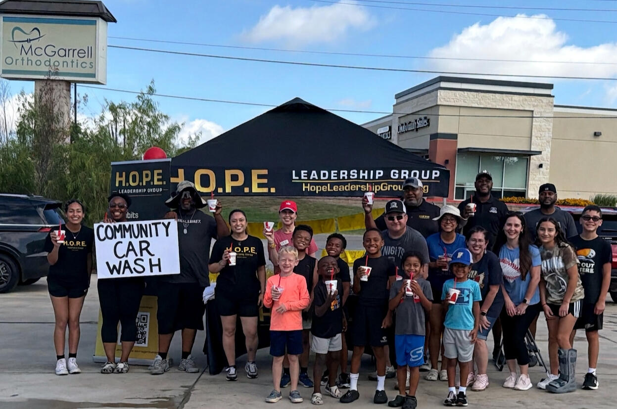 Mentors and mentees participate in a H.O.P.E. Leadership Group community car wash